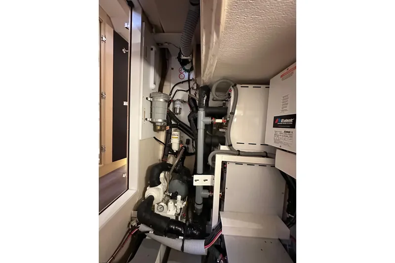 Slide: The Image of Engine room of a 2017 Jeanneau 64 yacht, showcasing mechanical components and systems. - 136