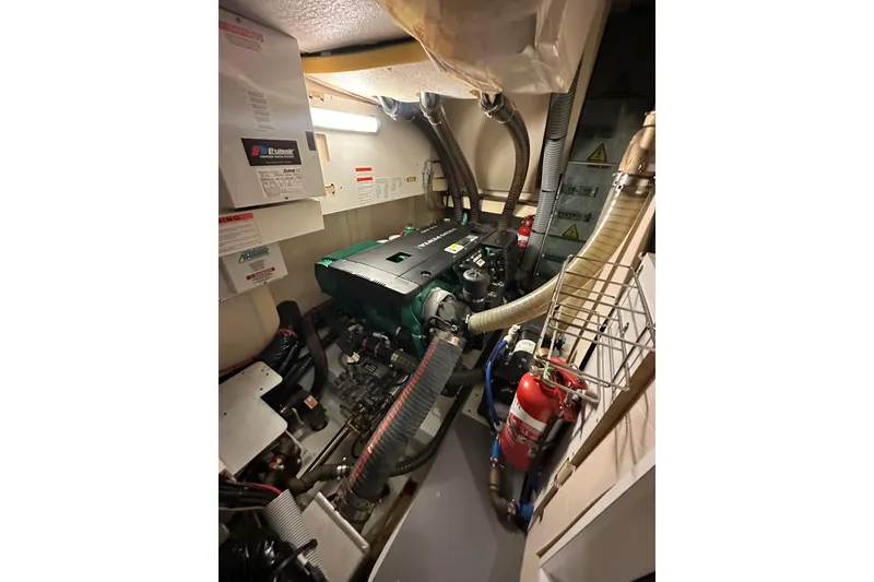 Slide: The Image of Engine room of 2017 Jeanneau 64 yacht with visible machinery and fire extinguisher. - 139
