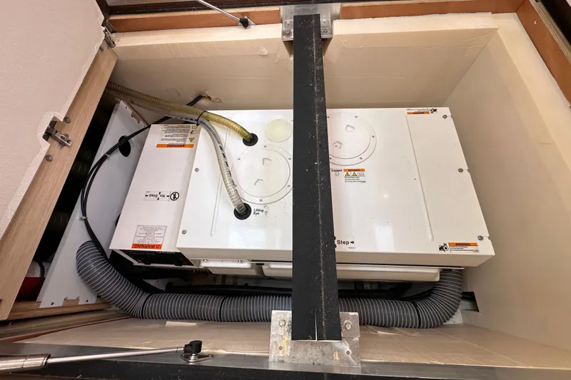 Slide: The Image of Engine compartment of a 2017 Jeanneau 64 yacht, showcasing mechanical components and hoses. - 141