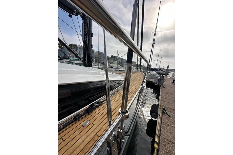 Slide: The Image of Jeanneau 64 yacht, 2017 model, docked with wooden deck and metal railings. - 18