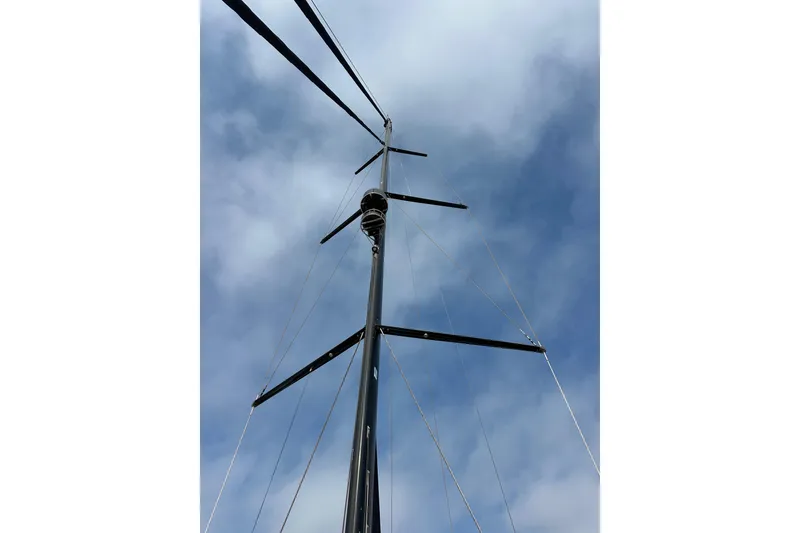 Slide: The Image of Tall mast of a 2017 Jeanneau 64 sailboat against a cloudy sky. - 29