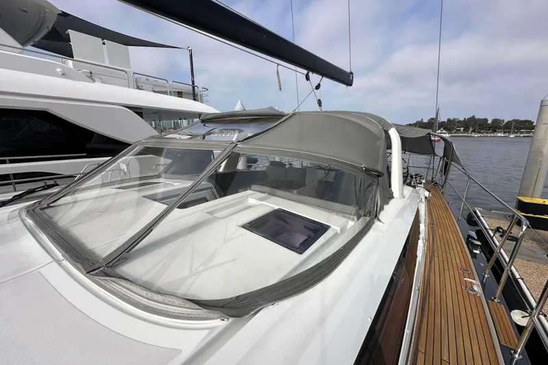 Slide: The Image of 2017 Jeanneau 64 yacht with sleek design, docked at marina, featuring spacious deck and canopy. - 32