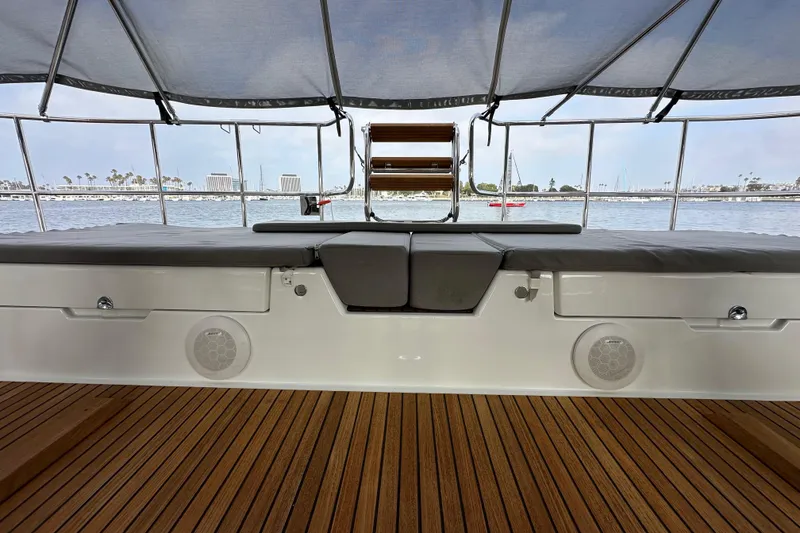 Slide: The Image of 2017 Jeanneau 64 yacht deck with cushioned seating and scenic marina view. - 38