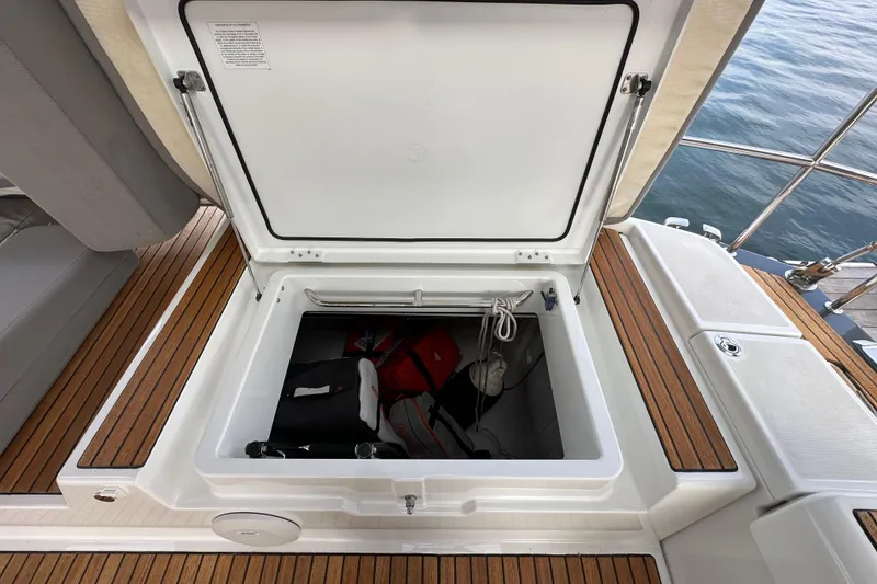 Slide: The Image of Open storage compartment on 2017 Jeanneau 64 yacht with wooden deck and safety equipment. - 40