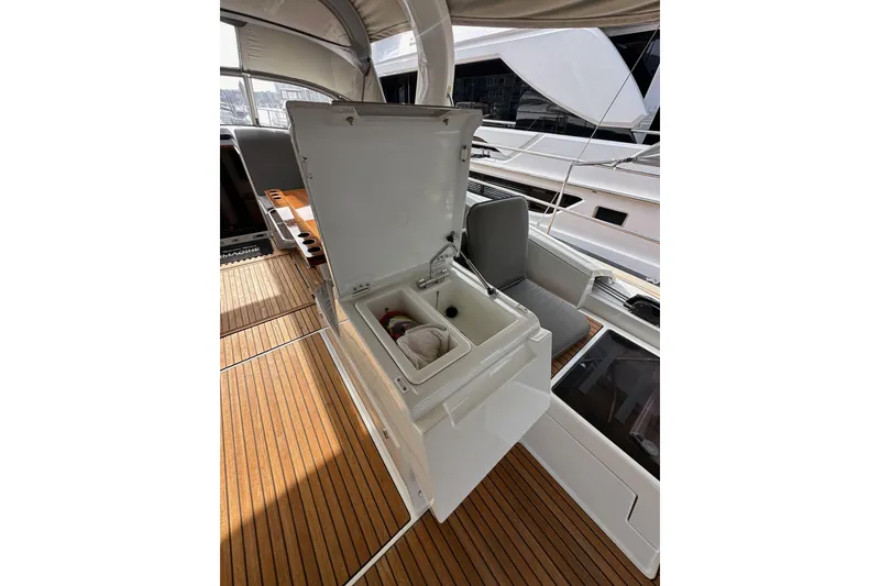 Slide: The Image of Open storage compartment on 2017 Jeanneau 64 yacht deck with wooden flooring. - 59