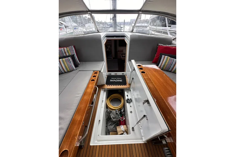 Slide: The Image of 2017 Jeanneau 64 yacht interior with open storage, cushions, and striped pillows. - 63