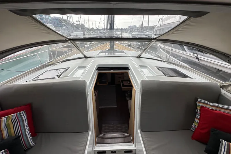 Slide: The Image of Interior view of 2017 Jeanneau 64 yacht with cushioned seating and colorful pillows. - 64