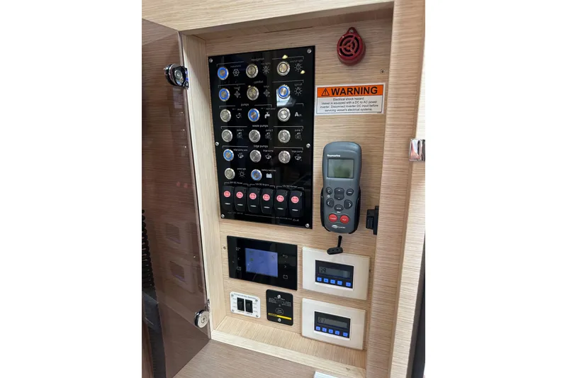 Slide: The Image of Control panel of a 2017 Jeanneau 64 yacht with various switches and displays. - 75