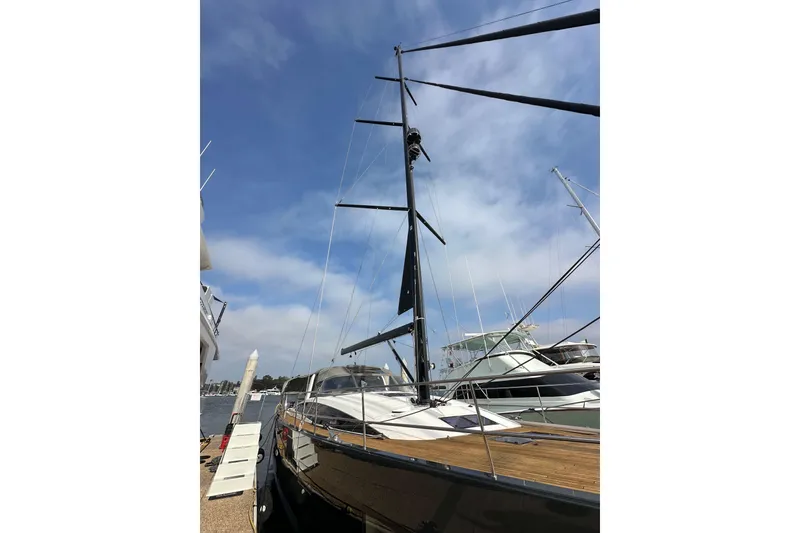 Slide: The Image of 2017 Jeanneau 64 sailboat docked, showcasing sleek design and tall mast under a clear sky. - 9
