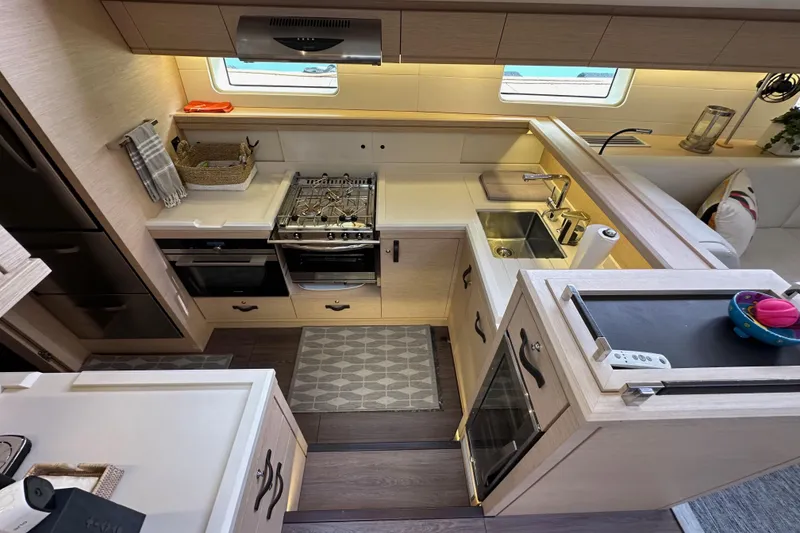 Slide: The Image of Modern kitchen interior of 2017 Jeanneau 64 yacht with stove, sink, and storage. - 90