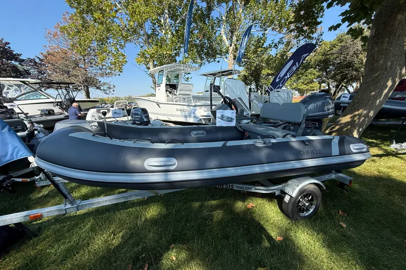 The Image of 2025 Highfield Classic 380 inflatable boat on trailer, displayed outdoors under trees. - 0