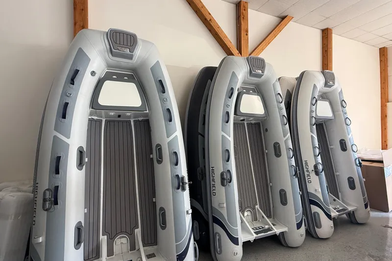Slide: The Image of Four 2025 Highfield Classic 380 inflatable boats stored vertically indoors. - 7