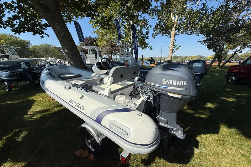 Slide: The Image of 2025 Highfield Classic 380 inflatable boat with Yamaha outboard motor displayed outdoors. - 2