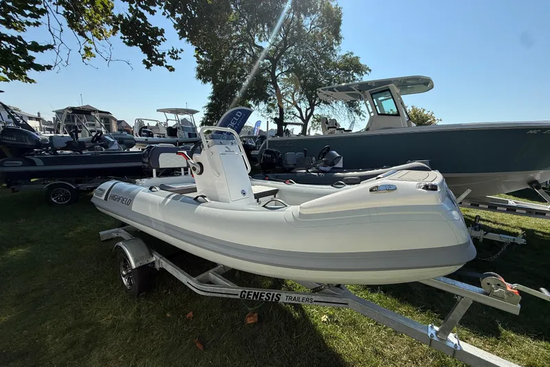 The Image of 2025 Highfield Sport 360 boat on trailer, displayed outdoors at a boat show. - 0