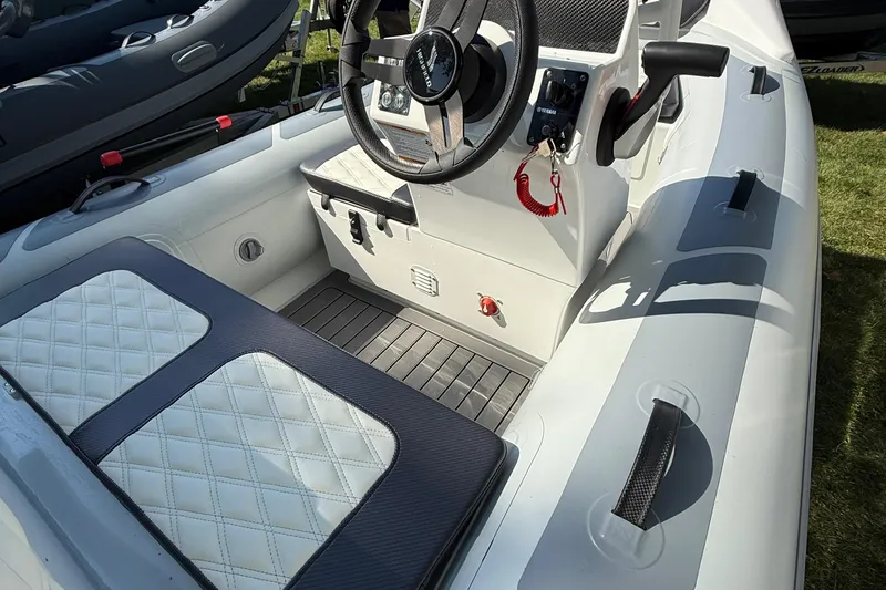 Slide: The Image of 2025 Highfield Sport 360 boat interior with steering wheel and cushioned seating. - 5