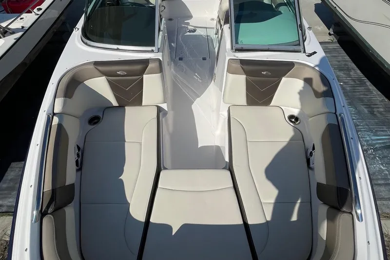 Slide: The Image of 2019 Chaparral 210 Suncoast boat interior with beige seating and cup holders. - 10
