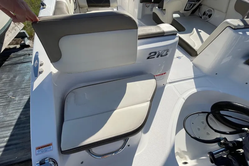 Slide: The Image of 2019 Chaparral 210 Suncoast boat interior with white seating and sleek design. - 26
