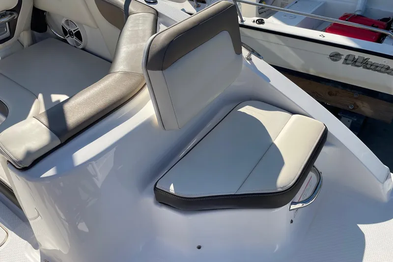 Slide: The Image of 2019 Chaparral 210 Suncoast boat interior seating with cushioned seats and speaker. - 27