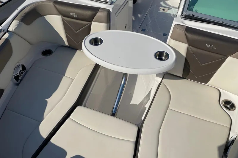 Slide: The Image of 2019 Chaparral 210 Suncoast boat interior with seating and table, featuring cup holders. - 29