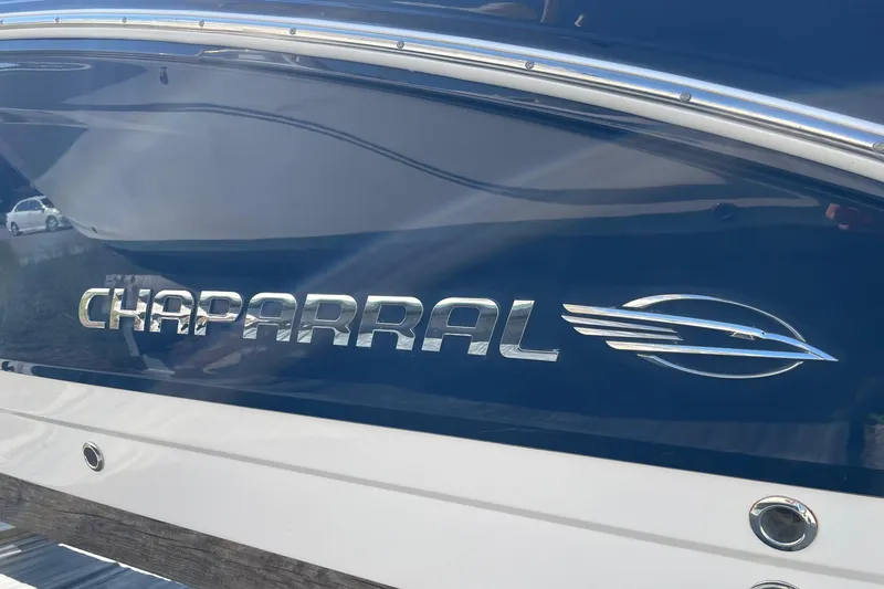 Slide: The Image of 2019 Chaparral 210 Suncoast boat logo on blue and white hull. - 40