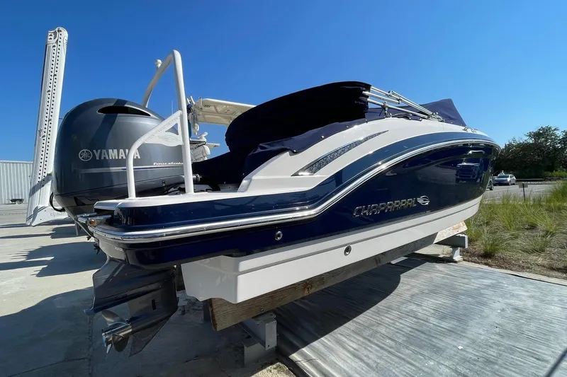 Slide: The Image of 2019 Chaparral 210 Suncoast boat with Yamaha engine, docked outdoors under clear blue sky. - 5