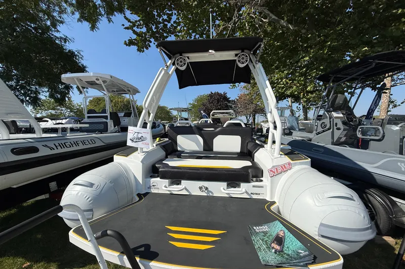 Slide: The Image of Highfield VELOX 560 boat, 2025 model, displayed outdoors with seating and canopy. - 5