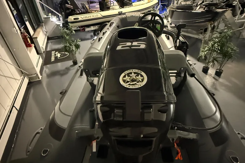 Slide: The Image of 2025 Highfield Classic 340 boat with 25 HP engine displayed indoors. - 2