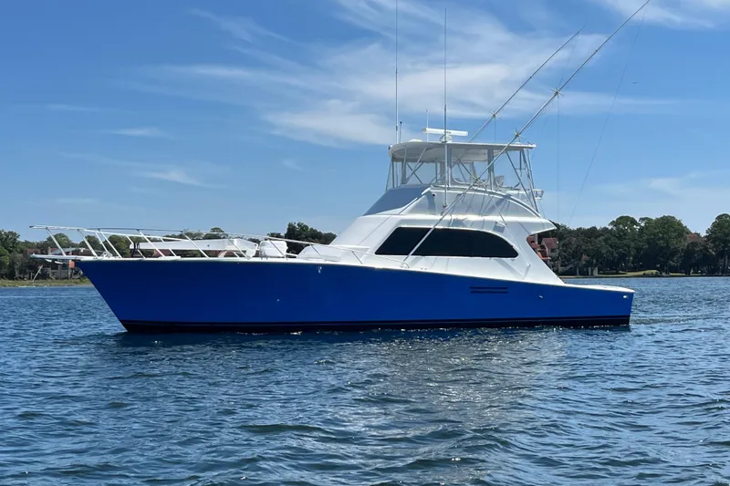 The Image of 1997 Post Sportfish boat on water, blue hull, clear sky background. - 0