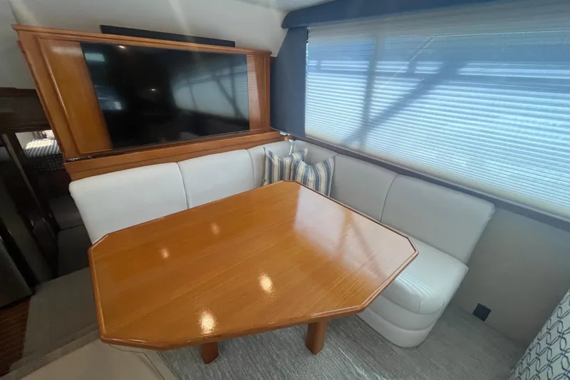 Slide: The Image of Luxurious 1997 Post Sportfish yacht interior with wooden table and white seating. - 24