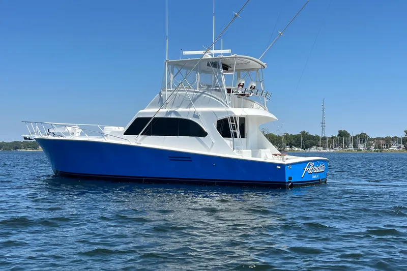Slide: The Image of 1997 Post Sportfish boat with blue hull on calm water under clear sky. - 3