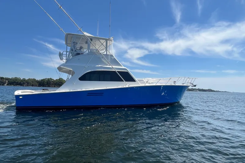Slide: The Image of 1997 Post Sportfish boat cruising on open water under a clear blue sky. - 4
