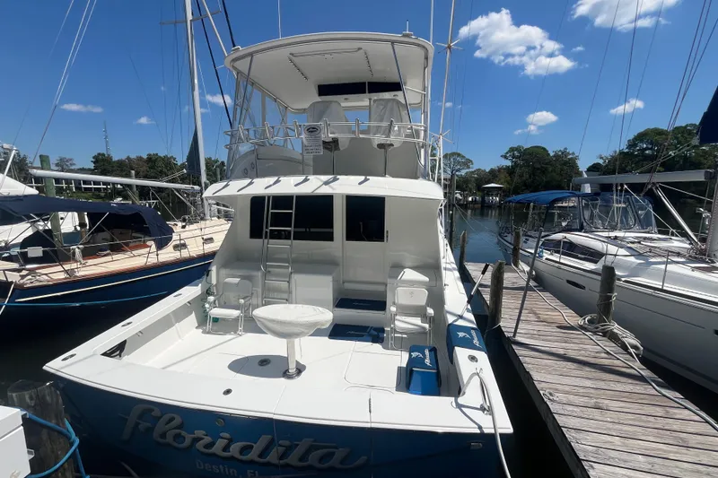 Slide: The Image of 1997 Post Sportfish boat docked at marina under clear blue sky. - 67