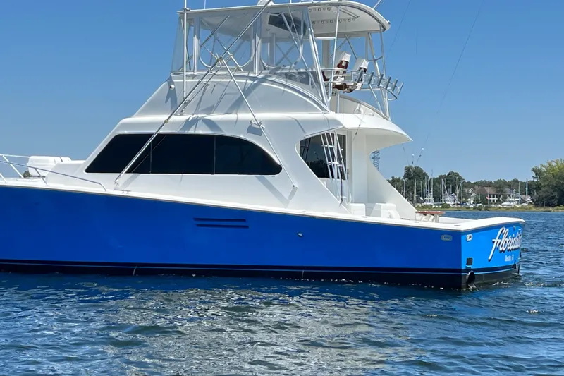 Slide: The Image of 1997 Post Sportfish boat with blue hull on calm water. - 2