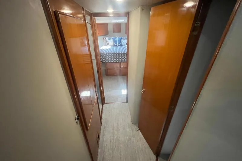 Slide: The Image of Hallway view inside 1997 Post Sportfish boat, leading to a cozy bedroom. - 28
