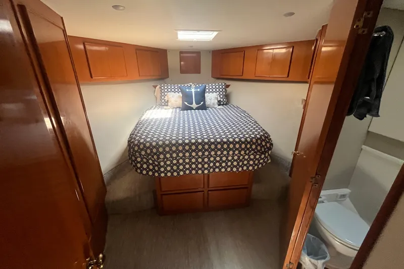 Slide: The Image of Cozy cabin interior of 1997 Post Sportfish boat with patterned bedding and wooden cabinets. - 33
