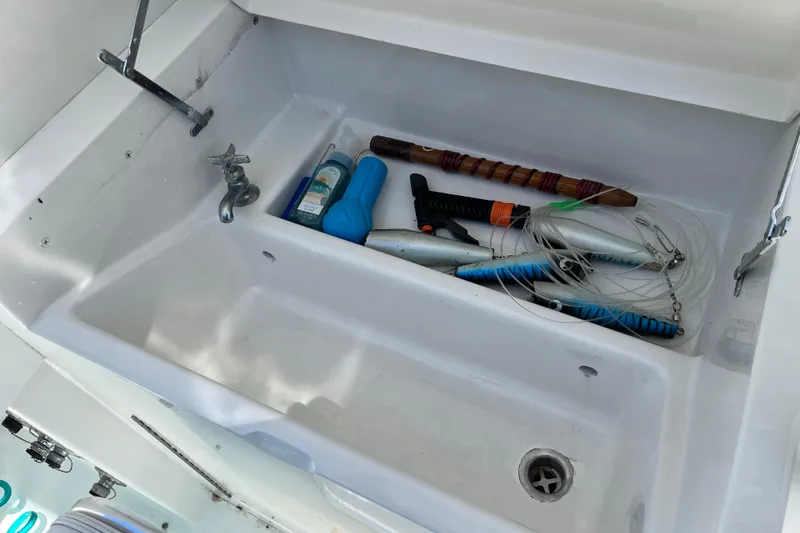 Slide: The Image of 1997 Post Sportfish boat sink with fishing gear and cleaning supplies. - 44