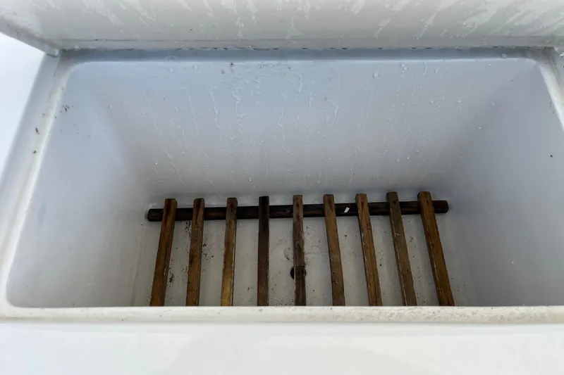 Slide: The Image of Empty cooler compartment with wooden slats in a 1997 Post Sportfish boat. - 45