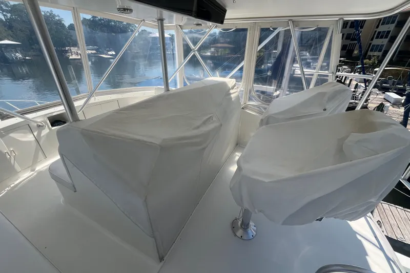 Slide: The Image of 1997 Post Sportfish boat interior with covered seats and helm, docked by the water. - 46