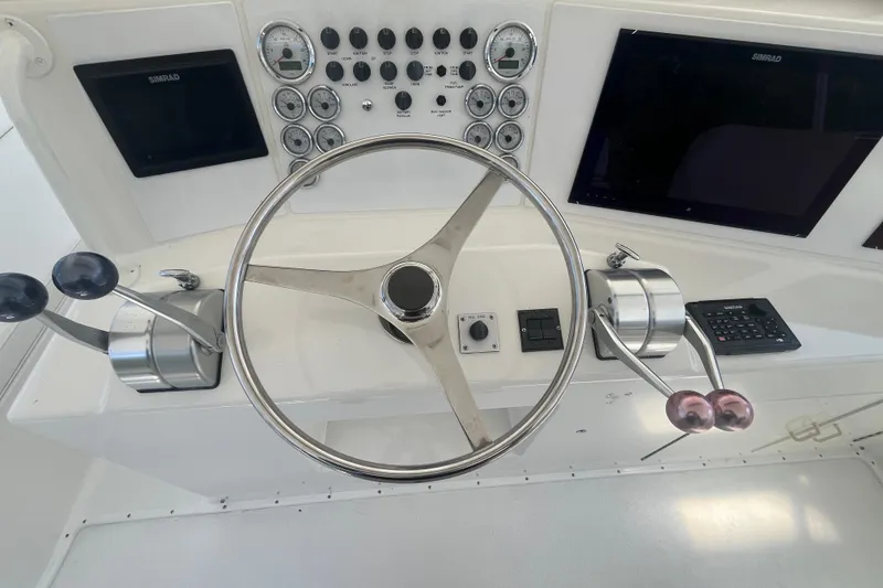 Slide: The Image of 1997 Post Sportfish helm with steering wheel, controls, and navigation displays. - 47