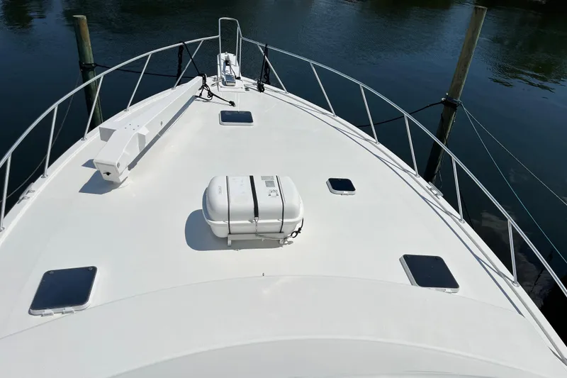 Slide: The Image of 1997 Post Sportfish boat deck with railing and life raft, docked on calm water. - 65