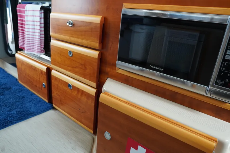 Slide: The Image of Interior of 2015 Cutwater 30 Command Bridge with wooden cabinetry and built-in microwave. - 15