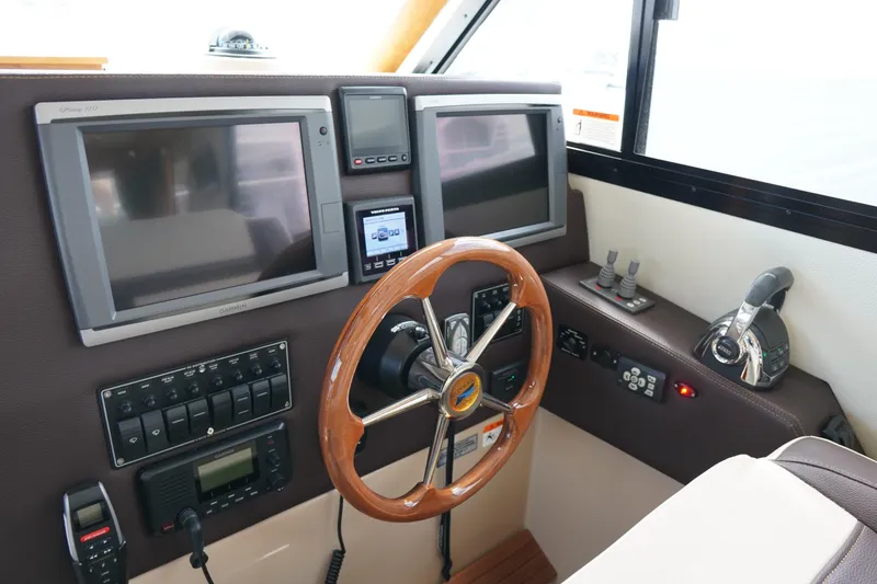 Slide: The Image of 2015 Cutwater 30 Command Bridge helm with dual screens and wooden steering wheel. - 17