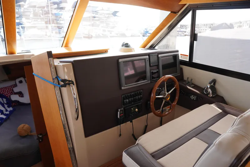 Slide: The Image of Interior helm of 2015 Cutwater 30 Command Bridge with steering wheel and navigation screens. - 18