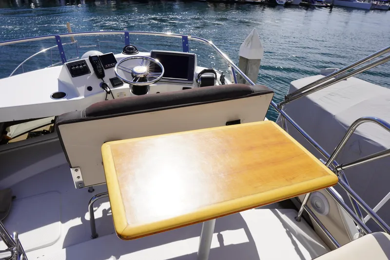 Slide: The Image of 2015 Cutwater 30 Command Bridge helm with wooden table and ocean view. - 6