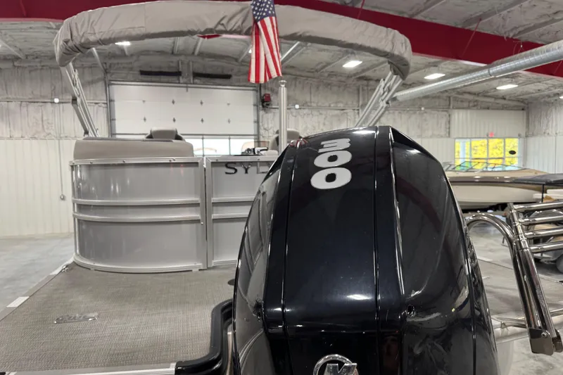 Slide: The Image of 2022 Sylvan L 5 pontoon boat with powerful 300 HP engine in a showroom. - 12