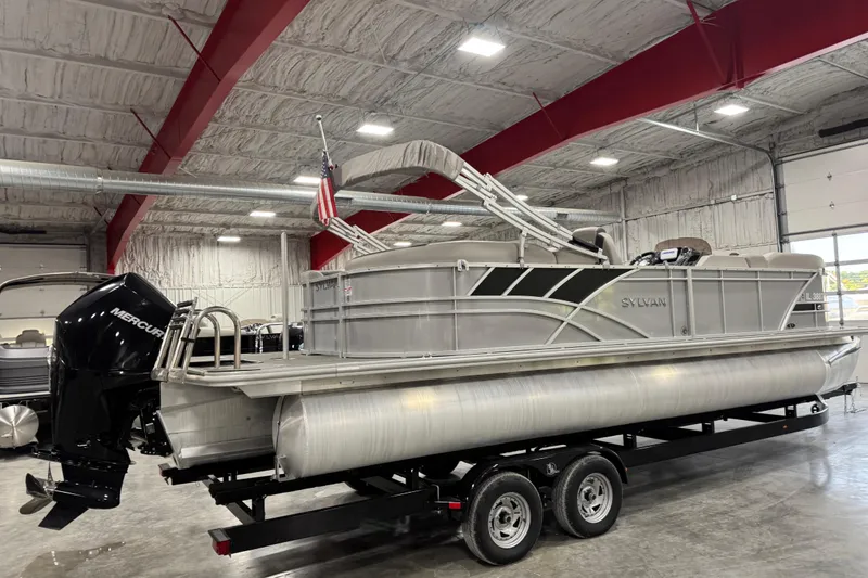 Slide: The Image of 2022 Sylvan L 5 pontoon boat in a showroom, featuring a Mercury outboard motor. - 3