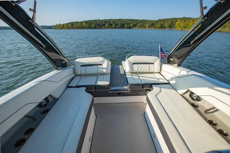 Slide: The Image of 2020 Regal LS6 boat interior with luxurious seating on a serene lake. - 11