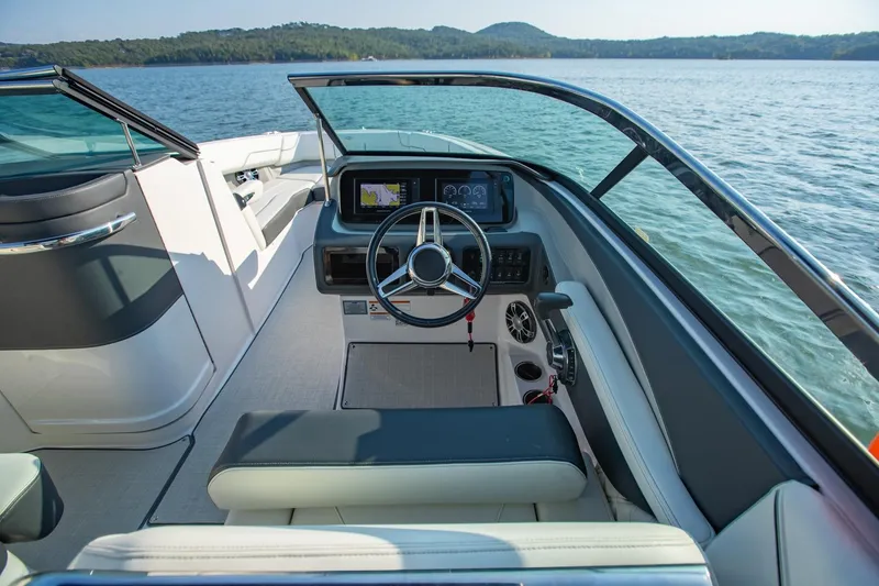 Slide: The Image of 2020 Regal LS6 boat cockpit with steering wheel and dashboard, overlooking serene lake. - 17