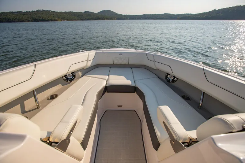 Slide: The Image of 2020 Regal LS6 boat interior with luxurious seating on a serene lake. - 24