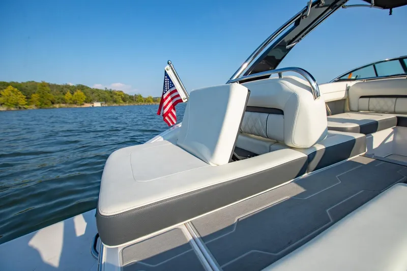 Slide: The Image of 2020 Regal LS6 boat interior with American flag on a sunny lake. - 9